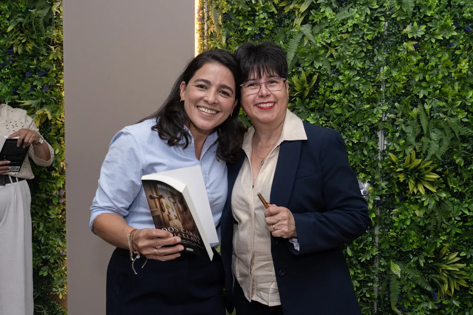 Rosa María Bello abraza a una lectora que sostiene el libro